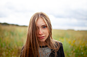 Portrait einer blonden Frau mit Blick in die Kamera in einem Feld