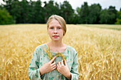 Portrait einer jungen Frau mit kleinem Kranz in einem Weizenfeld