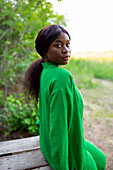 Frau mit grüner Bluse, Blick über die Schulter