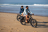 Two young men riding their bikes on the sand during Quiksilver Festival celebrated in Capbreton, Hossegor and Seignosse, with 20 of the best surfers in the world hand-picked by Jeremy Flores to compete in south west of France.\n