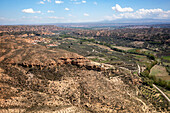 Drohnenaufnahme einer Straße durch eine wüstenähnliche Landschaft in der Nähe des Francisco Abellan-Staudamms und -Stausees, Granada, Andalusien, Spanien, Europa