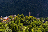 Die Gemeinde Varzo aus der Ferne gesehen,mit Dächern und Türmen über dem Bergwald,Varzo,Piemont,Norditalien,Europa
