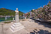 Blick auf Statue und bunte Häuser in Assos, Assos, Kefalonia, Ionische Inseln, Griechische Inseln, Griechenland, Europa