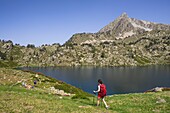 Frankreich, Hautes Pyrenees, oberer Bastan-See und Gipfel des Bastan (2724m), Wanderer entlang des oberen Bastan-Sees