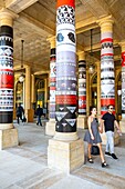 France, Paris, the garden of the Palais Royal, photo exhibition on the columns\n
