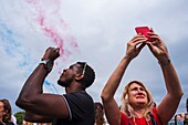France, Paris, July 14th parade (Bastille Day), couple photographing the aerial parade\n