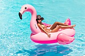 France, Caribbean, Lesser Antilles, Guadeloupe, Grande-Terre, Saint-François, Bwa Chik hotel, woman relaxing on a buoy in the swimming pool\n