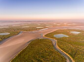 France, Somme, Bay of Somme, Noyelles-sur-mer, the salted meadows of the Bay of the Somme in the early morning with the channels and the pools of hunting huts, a little mist, and Saint-Valery-sur-Somme in the background (aerial view)\n