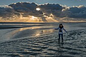 Frankreich, Somme, Somme-Bucht, Naturschutzgebiet der Somme-Bucht, Landschaften der Somme-Bucht bei Ebbe, ein Kind überquert Bäche im Sonnenuntergang