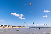 "France, Somme, Bay of the Somme, Le Crotoy, Crotoy beach is a spot for kitesurfing and windsurfing; in the aftermath of a storm, while the sun has returned with a powerful wind, the athletes are numerous and their multicolored sails brighten up the landscape"\n