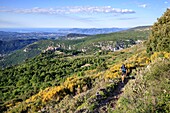 Frankreich, Alpes Maritimes, Regionaler Naturpark der Prealpes d'Azur, Gourdon, Trailrunner auf dem GR51, das Dorf Gourdon und die Küste der Côte d'Azur im Hintergrund