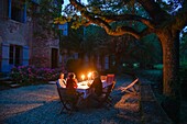 France, Saone et Loire, La Roche, candlelight dinner under a tree on a property\n