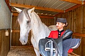 France, Oise, Chantilly, Chateau de Chantilly, the Grandes Ecuries (Great Stables), Estelle, rider of the Grandes Ecuries, preparing his horse\n