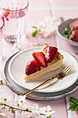 Ein Stück Vanillepudding-Tarte mit frischen Erdbeeren