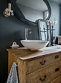 Rustic wooden chest of drawers as a washstand in the bathroom