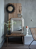 Wooden table with mirror and flower vase, wooden boards as wall decoration