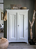 White vintage cupboard with decoration in rustic living room