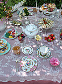 Coffee table in the garden with fine china and home-baked pastries and finger food