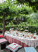 Coffee table in the garden with cakes and pastries on a decorated tablecloth