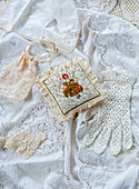 Vintage lace and embroidered pincushion on white crocheted textiles