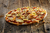 Sauerteig-Pizza mit Tomatensauce, Pancetta, Calamaretti und Artischocken