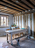 Dining area in a room with rustic ambiance with wooden beam ceiling