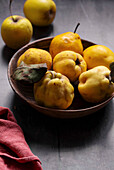 Yellow quinces, apples and pears in a wooden bowl