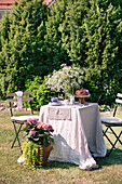 Table setting with flowers and ring cake in the summer garden