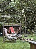 Gemütliche Sitzecke mit Rattansesseln und Feuerstelle im Garten