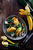 Salad with stuffed zucchini flowers, goat's cheese and olives