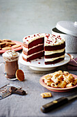 Red velvet chocolate cake with cream cheese icing, hot chocolate, mini fig rolls