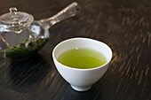 Grüner Tee mit Sakurablüten in Teeschale (zum Kirschblütenfest, Japan)