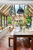 Dining room in the conservatory with large table and terracotta tiles