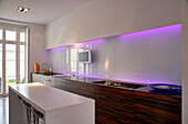 White galley kitchen with purple lighting and kitchen island