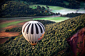 Hot air balloon flying over volcanic field
