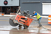 Worker operating concrete saw