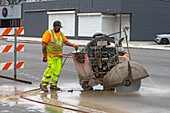 Worker operating concrete saw