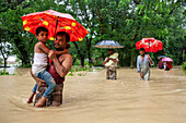 People walking through floodwater, Satkania Upazila, Bangladesh