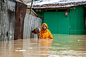 Woman walking through floodwater, Satkania Upazila, Bangladesh