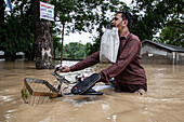 Man travelling through floodwater, Satkania Upazila, Bangladesh