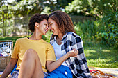 Happy lesbian couple on picnic blanket