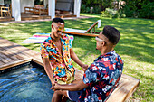 Young gay male couple relaxing in swimming pool