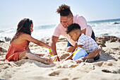 Family making sandcastle on beach