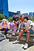 Young friends using smart phones in park