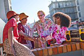 Young friends with boom box joining hands on rooftop