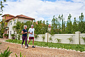 Active senior couple walking on footpath