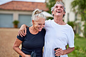 Senior couple with water bottles laughing