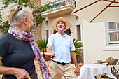 Senior couple dancing outside summer villa