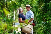 Senior couple hugging under lush green trellis
