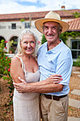 Senior couple hugging in villa garden